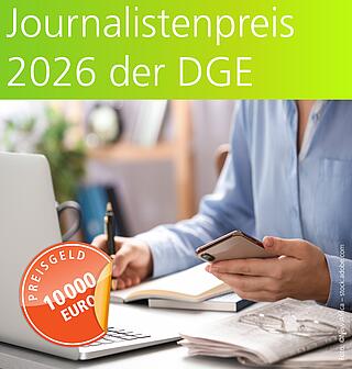 Journalisten-Preis 2026 der DGE, Gesamt-Preisgeld 10000 Euro, Eine Person vor einem Notebook sitzend, schreibt mit einem Stift, in der linken Hand ein Smartphone. Es liegen Bücher und eine Zeitschrift auf dem Tisch